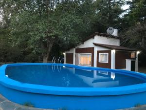 奇维尔科伊Chalet con piscina的一座大型蓝色游泳池,后面有一座房子