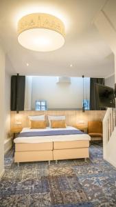 阿姆斯特丹纳斯酒店的一间卧室配有一张床和一个大型吊灯。