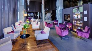 维多利亚-加斯特伊兹斯考特而维多利亚-加斯特兹大道酒店的大堂设有白色椅子和紫色椅子