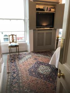 都柏林黑石住宿加早餐旅馆的一间设有地毯、椅子和电视的房间