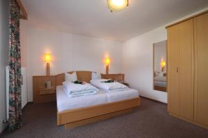 费斯布彻哈默尔酒店的一间卧室配有一张带白色床单和镜子的床