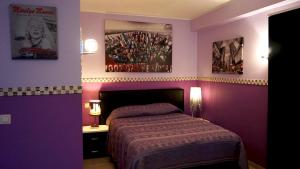布鲁塞尔巴拉迷笛公寓式酒店的一间卧室设有紫色的墙壁、一张床和两张海报
