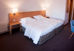 Süderbrarup安格勒霍夫酒店的酒店客房设有一张大床和一个床头柜。