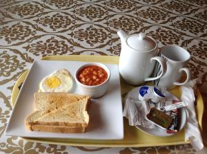 阿克拉Benconi Lodge的包括鸡蛋、面包和豆子的早餐盘