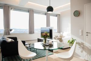 维也纳维也纳菲尔斯普乐斯全方位服务式公寓的客厅配有玻璃桌和白色椅子