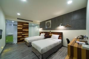 新竹新舍商旅新竹馆的酒店客房配有两张床和一张书桌