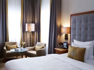 慕尼黑普拉茨尔酒店 - 高级的配有床、椅子和桌子的酒店客房
