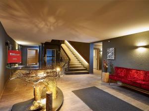 费尔德伯格黑森林公寓的一间带红色沙发和楼梯的客厅