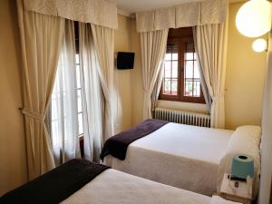 阿维拉阿尔坎塔拉旅舍的一间卧室设有两张床和窗户。