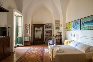 莱切Palazzo Bernardini Suites的一间卧室配有一张床,并在一间客房内配有电视。