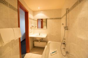 奥斯坦德Hotel Rubens的带浴缸、水槽和淋浴的浴室