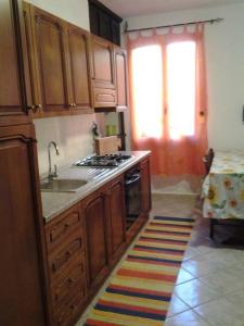卡拉古诺内Casa vacanze da Francesca的厨房配有木制橱柜、水槽和炉灶。