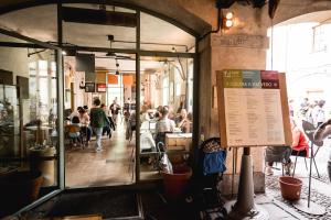 米兰Un posto a Milano - guesthouse all'interno di una cascina del 700的一群坐在餐厅桌子上的人