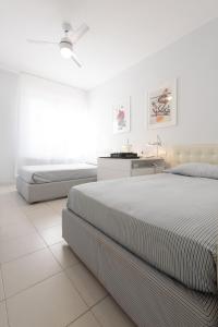 蓬塔阿拉Punta Ala Luxury Villa的一间白色卧室,配有两张床和一张书桌