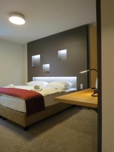 乌尔姆纽托尔酒店的一间卧室配有一张大床和一张书桌