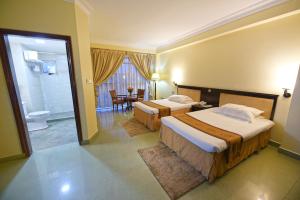 坎帕拉Hotel Sojovalo的酒店客房带两张床和一间浴室