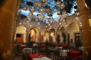 莫雷利亚阿拉米达历史中心酒店的用餐室配有桌椅和吊灯。