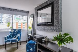 巴拿马城Riande Urban Hotel的客房设有书桌、椅子和镜子