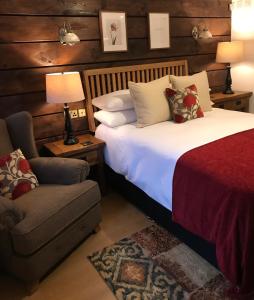 伍尔弗汉普顿Boutique Garden Lodge @ The Larches的一间卧室配有一张床、一把椅子和一张沙发