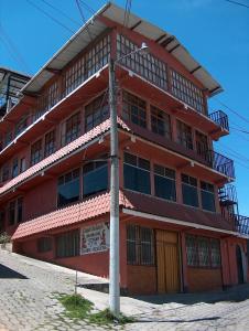 克萨尔特南戈Casa Xelaju Apartments的前面有杆的红色建筑