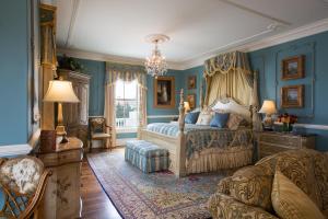 纽波特尚勒崖城酒店的卧室拥有蓝色的墙壁,配有一张床和一张沙发