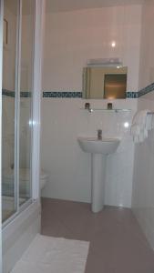 巴黎德沃奇酒店的白色的浴室设有水槽和淋浴。