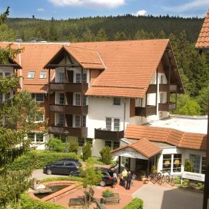 布劳恩拉格relexa hotel Harz-Wald Braunlage GmbH的享有酒店空中景色,在庭院里停放汽车