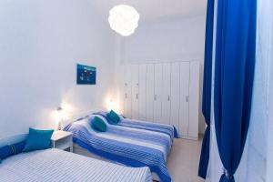 科尔丘拉Korcula apartmanu Mili的一间卧室配有两张带蓝色枕头的床