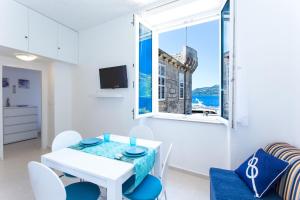 科尔丘拉Korcula apartmanu Mili的白色的用餐室配有桌椅和窗户。