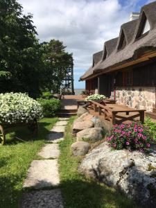 HaeskaTuulingu Guest House at Matsalu National Park的前面有长椅和鲜花的房子