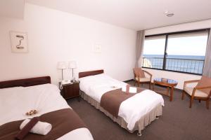 Isohara磯原海边酒店的酒店客房设有两张床和大窗户。