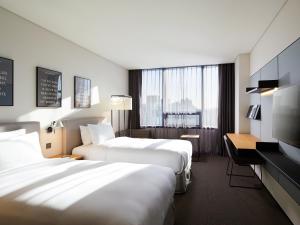 首尔GLAD Mapo的酒店客房配有两张床和一张书桌