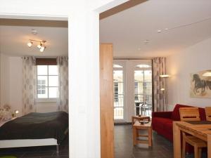 巴贝Ferienwohnung-Adlerhorst的一间卧室和一间带红色沙发的客厅