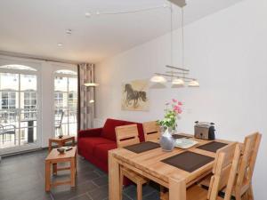 巴贝Ferienwohnung-Adlerhorst的客厅配有桌子和红色沙发