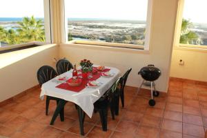 滨海罗克塔斯Villa Romana Roquetas的一间带桌椅和窗户的用餐室