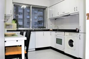 圣地亚哥－德孔波斯特拉Apartamento Lula的厨房配有白色橱柜、洗衣机和烘干机