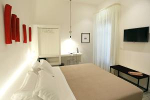 雷焦卡拉布里亚Re Ruggero Rooms的一间白色卧室,配有床和电视