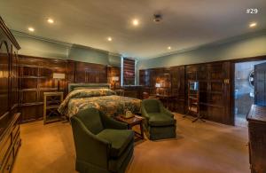 斯坦福德斯坦福乔治酒店的一间卧室配有一张床和两把椅子