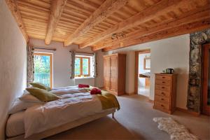 拉夏贝尔德邦达La Ferme du Château的一间卧室设有一张大床和木制天花板