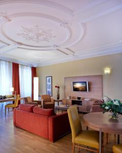 斯特拉斯堡馨乐庭斯塔伯格克雷贝酒店的客厅配有红色的沙发和桌子