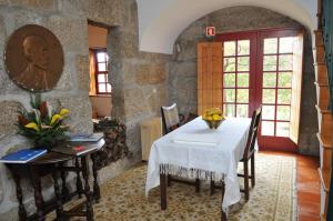 Santa Cruz do DouroCasa do Silvério的一间设有白色桌子和石墙的用餐室