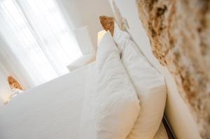 阿尔贝罗贝洛席尔瓦酒店的窗户客房内的一张带白色枕头的床