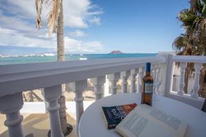 科拉雷侯加莱拉海滩公寓酒店的一瓶葡萄酒和一本书,在海滩阳台上