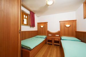 瓦格赖恩Appartements Kaswurm的小型客房配有2张床铺和木制橱柜。