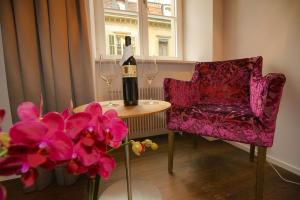 布格多夫Boutique Hotel - Restaurant Orchidee的桌椅上的一瓶葡萄酒和鲜花
