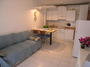 格拉多Villa Gradenigo的客厅配有沙发和餐桌,厨房配有桌子