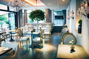 慕尼黑慕尼黑皇宫酒店的餐厅设有桌椅和吊灯。