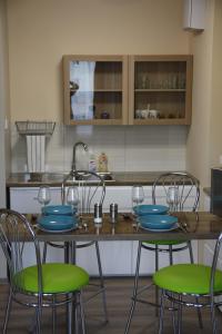 罗兹Apartament Tabaco的厨房配有带四把椅子的桌子和水槽