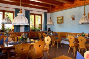 罗滕堡老木匠酒店的用餐室配有木桌和椅子