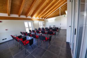 FariglianoAgriostello delle Langhe的配有桌椅和木制天花板的客房